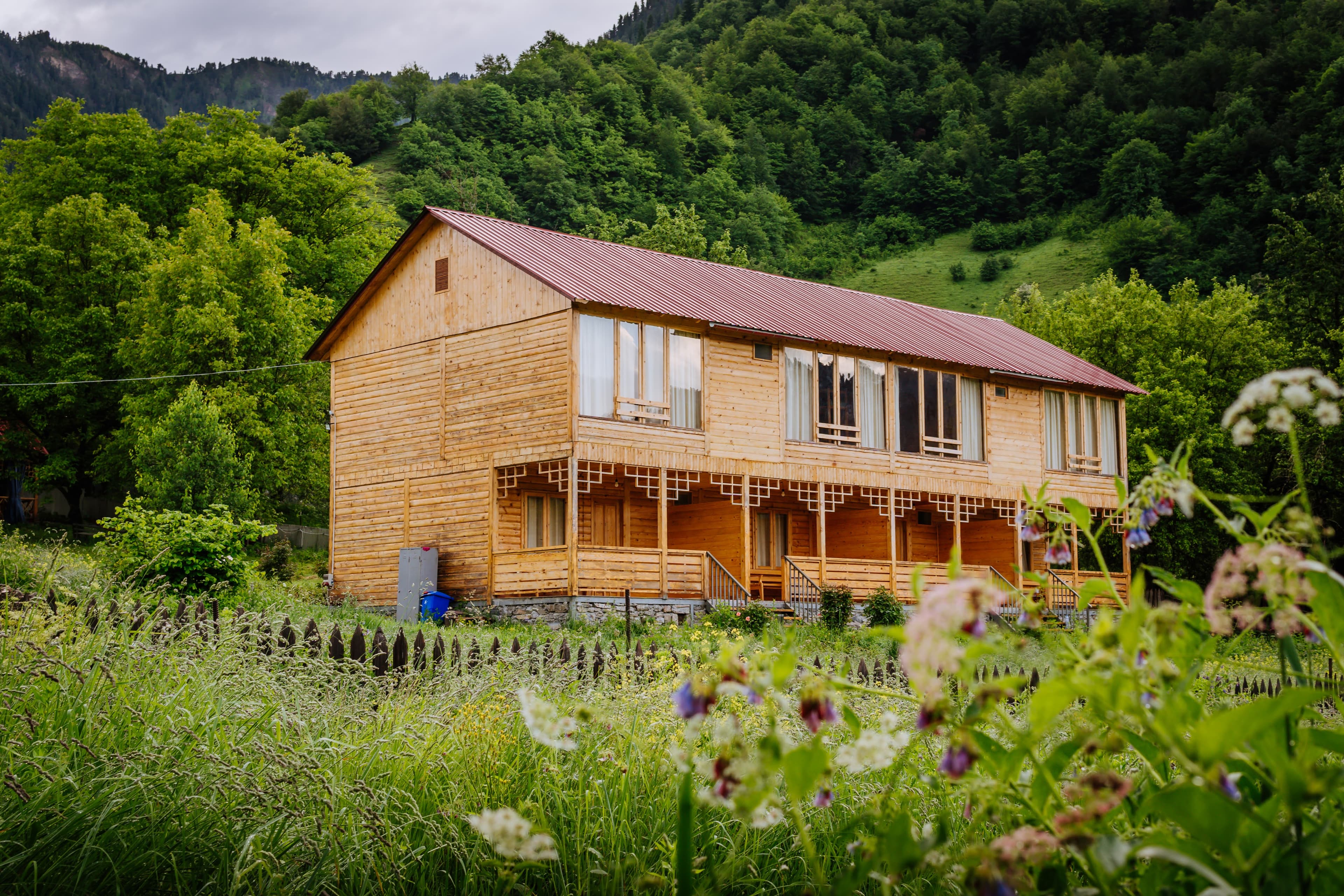 Chiora Inn lodge surrounded by wildflowers and Racha mountains