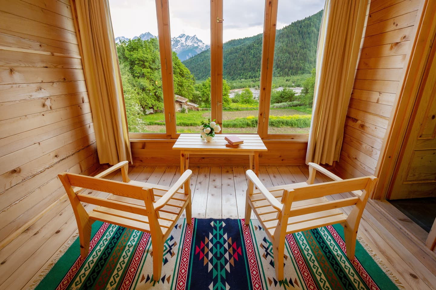 Cozy room with chairs facing panoramic valley and mountain views
